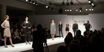 Modelos desfilando en una pasarela de un evento de moda en España, con público y fotógrafos.