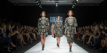 Pasarela de moda en España con modelos y público, simbolizando la reducción de costos en eventos.