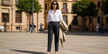 Minimalismo en la moda española: 10 looks con 5 prendas básicas 2025 Mujer española elegantemente vestida con un conjunto minimalista en una plaza de Sevilla, mostrando la versatilidad de prendas básicas.